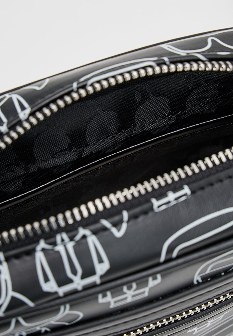 Bolso negro con patrones gráficos blancos, con cierre de cremallera y un forro interior texturizado, que muestra un diseño elegante y un material duradero.