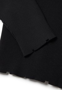 Tessuto nero a coste, con una finitura testurizzata e un orlo scalloppato. Due maniche con bordi sfilacciati sono mostrate in dettaglio.