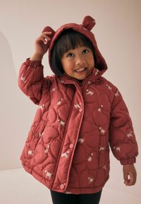 Veste matelassée rouge avec capuche en forme d'ours, ornée d'un motif ludique de petits chiens, de boutons pression et de manches élastiquées.