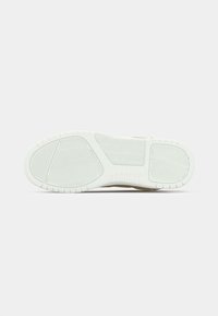 Hvitt gummisåle med teksturerte grep mønstre, inkludert horisontale, diagonal og fiskebensspor på en ensfarget bakgrunn.