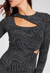 Robe noire à manches longues, ornée d'un motif tourbillonnant et de formes découpées. Fabriquée dans un tissu texturé et scintillant. Design ajusté.