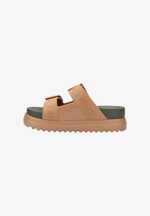 Tan Slide-Sandal mit breiten elastischen Riemen und geprägtem Markennamen, grünem Schaumfußbett und strukturiertem Gummioutsole.