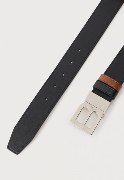 Μαύρη δερμάτινη ζώνη με πέντε τρύπες ρύθμισης, ασημένια ορθογώνια αγκράφα με σχέδιο κοπής και καφέ δερμάτινη λεπτομέρεια βρόχου.