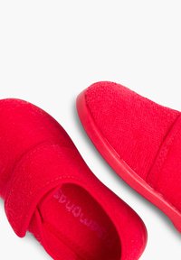 Scarpe in tessuto rosso con finitura testurizzata, dotate di una cinturino in Velcro, punta rotonda e suola in gomma coordinata. Rivestimento interno liscio.