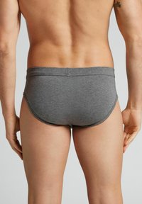 Grijze katoenen slip met een gladde textuur en elastische tailleband, met een aansluitend ontwerp dat zich naar het lichaam vormt en minimale stiksels heeft.