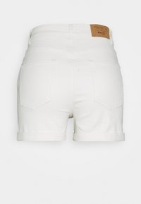 Pantalones cortos de mezclilla blanca con dobladillos enrollados, que cuentan con dos bolsillos traseros y una etiqueta marrón en la cintura. Textura suave y corte ajustado.