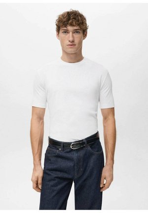 Weißes kurzärmeliges T-Shirt aus Baumwolle, taillierter Schnitt. Kombiniert mit dunkelblauen Jeans aus Denim und einem schwarzen Gürtel. Schlichte, klare Linien.