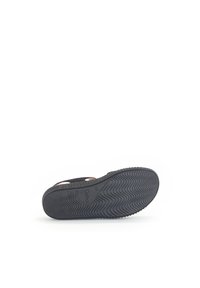 Black sandal with a textured rubber sole, featuring a woven upper and light tan accents. Bottom view shows tread pattern and branding.