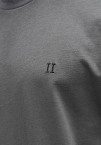 Szary T-shirt z okrągłym dekoltem i małym czarnym haftem "II" na piersi, wykonany z miękkiej bawełnianej tkaniny.