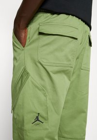 Groene cargoshorts van stevig materiaal, met meerdere zakken, een zwart Air Jordan-logo en een comfortabele elastische tailleband.