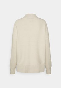 Maglione beige con collo alto, corpo a maglia texturizzata e polsini e orlo a coste, caratterizzato da spalle scese e una vestibilità rilassata.