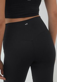 Mustad kõrge vöökohtadega legginsid, mis on valmistatud venivast kangast. Omavad siledat tekstuuri ja väikest valget logo "self." vöökoha lähedal.