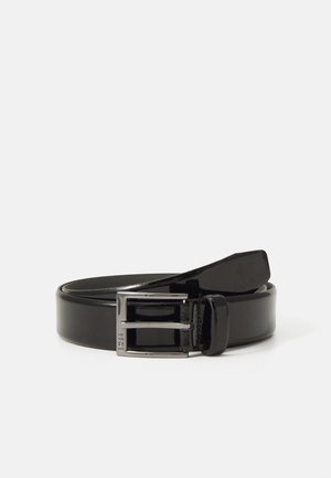 Ceinture en cuir noir enroulée avec une boucle rectangulaire argentée et le nom de la marque embossé sur le côté de la boucle.