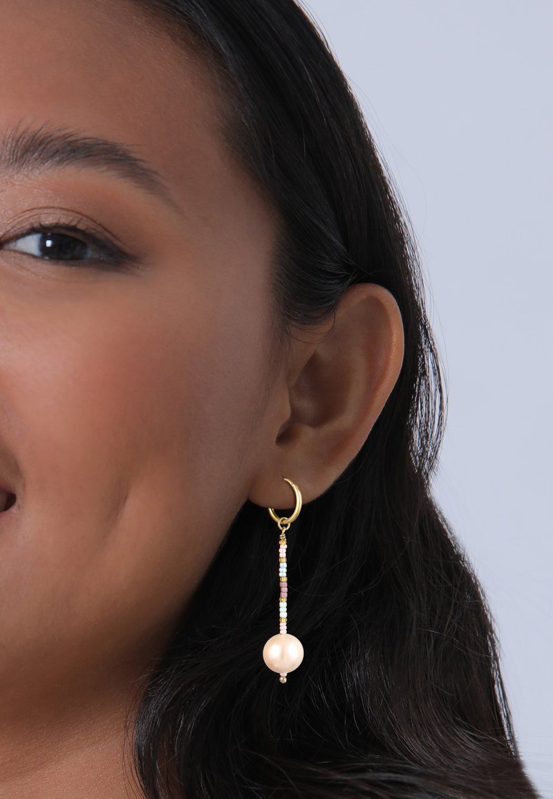 Guldørering med en hængende design, der har en stor perle og farverige perler i et gradientmønster. Glat tekstur, elegant form.