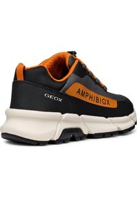 Zapato deportivo negro con acentos naranjas. Presenta una parte superior de tela texturizada, suela acolchada y una prominente etiqueta "AMHIBIOX" en el lateral.