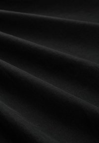 Schwarzer Stoff mit einer glatten Textur und subtilen Glanz, zeigt sanfte Falten und leichte Lichtvariationen auf seiner Oberfläche.
