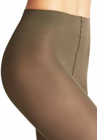 Collant opaco verde oliva con una texture liscia e opaca e un alto elastico in vita. Presenta un dettaglio di cucitura curva sottile.