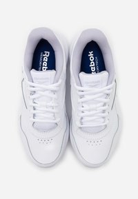 Paire de baskets blanches Reebok MemoryTech avec lacets, doublure intérieure grise et semelles intérieures bleu marine, vues de dessus sur fond blanc.