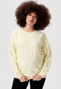 Lichtgele sweatshirt met lange mouwen, ronde halslijn en geribde manchetten. Zachte stof en een relaxte pasvorm met minimale stikdetails.