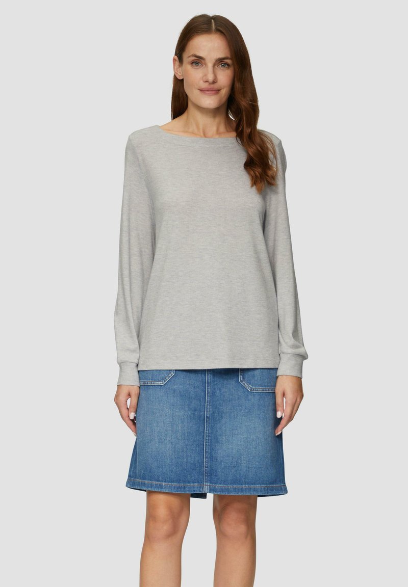 Lichtgrijs lange mouwtop met een boot halslijn, gecombineerd met een blauwe denimrok met twee voorzakken en een rechte snit.