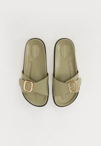 Olive green slide sandals with a cross-over strap and a gold buckle accent; flat soles with a textured insole and black rubber edges.