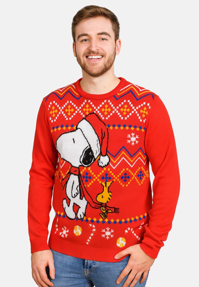 Maglione rosso lavorato a maglia con un design natalizio che presenta Snoopy con un cappello da Babbo Natale, arricchito da motivi e decorazioni colorate come fiocchi di neve.