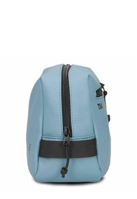 Blauwe waterdichte tas met een ronde vorm, voorzien van een centrale zwarte rits en een band met verstelbare hardware. Textuurdetails zichtbaar op het oppervlak.