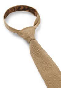Beige Strickkrawatte mit strukturiertem Muster, glattem Innenfutter und spitzem Ende. Sie verfügt über ein klassisches Knotendesign für sicheren Halt.