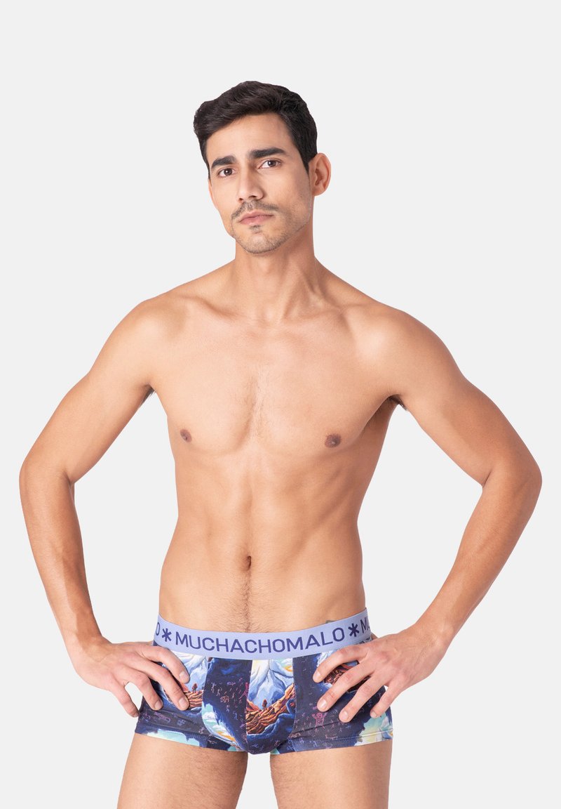Pánske boxerské šortky s farebným vzorovaným dizajnom a modrou elastickou gumou s nápisom "MUCHACHOMALO". Materiál sa zdá byť mäkký a hladký.