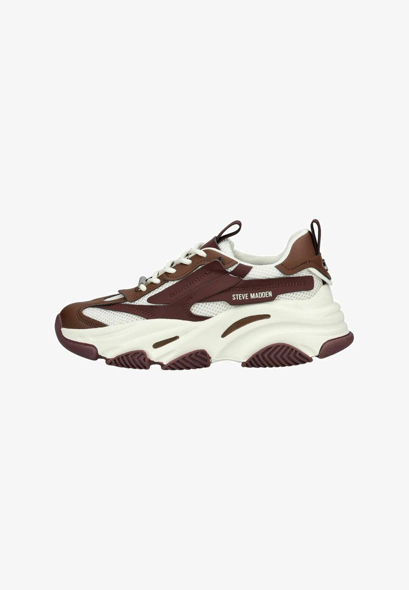 Scarpa sportiva marrone e bianca con materiale in rete e sintetico, suola spessa, distintivo motivo a zigzag sulla parte inferiore e lacci.