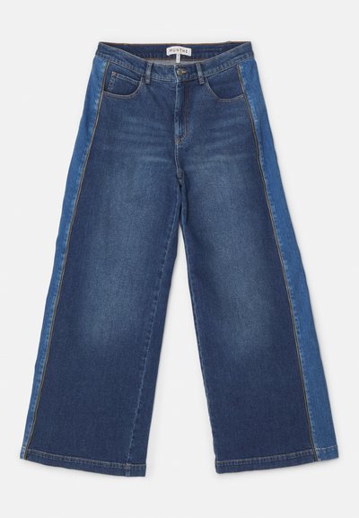 Weite Jeans in mittlerem und hellblauem Denim mit kontrastierenden Einsätzen. Verfügt über fünf Taschen, einen Reißverschluss und einen genähten Saum.