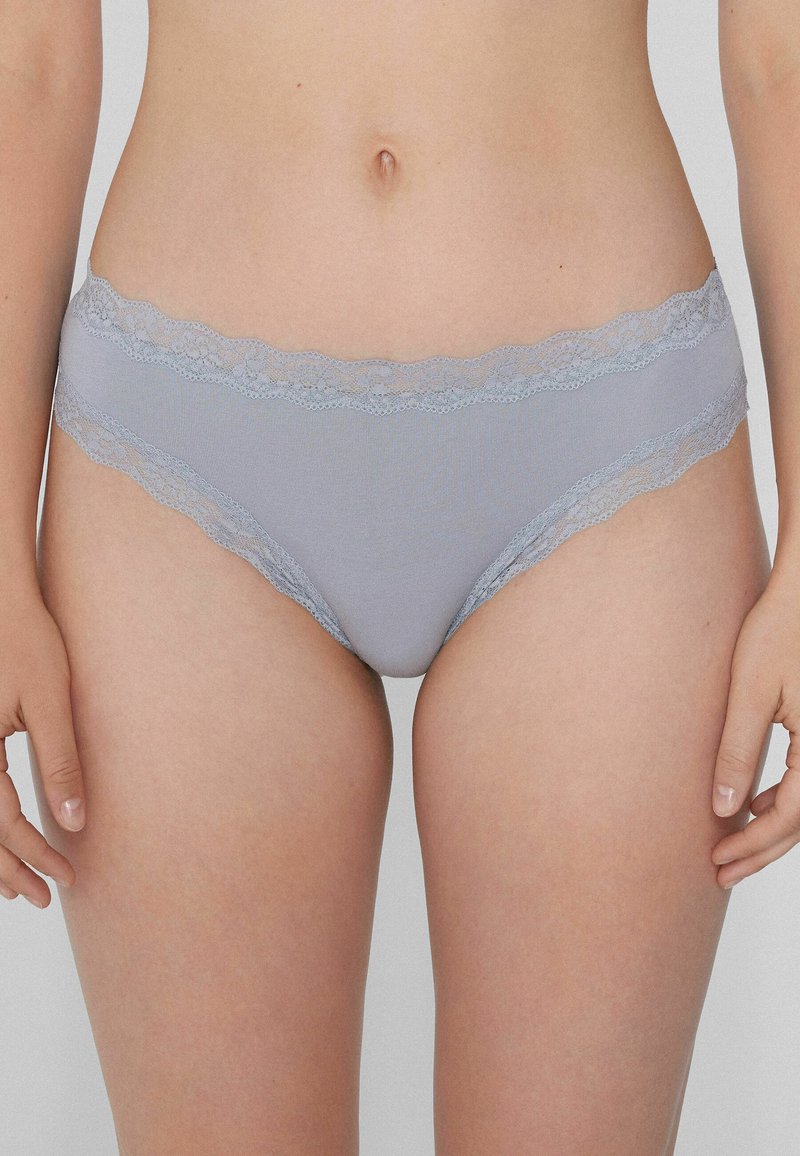 Sous-vêtements gris clair avec une finition en dentelle le long de la taille. Fabriqués en tissu doux, ils présentent une coupe modeste et une texture lisse.