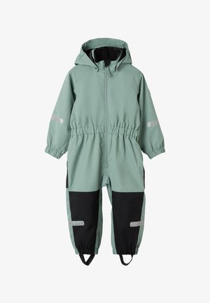 Combinaison imperméable vert clair avec capuche, taille élastique, accents noirs sur les côtés et bandes réfléchissantes sur les bras et les jambes.