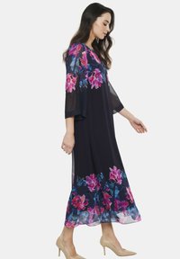 Długa granatowa sukienka w kwiatowy wzór w odcieniach różu i niebieskiego, przezroczyste rękawy ¾, zwiewny krój A-line, z długością do połowy łydki i miękką fakturą materiału.