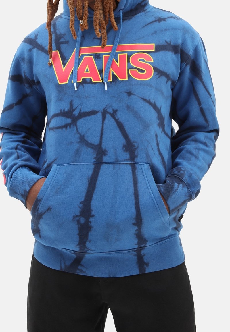 Blauer Batik-Hoodie mit einem großen roten "VANS"-Logo auf der Brust, einer Kängurutasche und Kordelzügen. Weicher Stoff, lockere Passform und lange Ärmel.