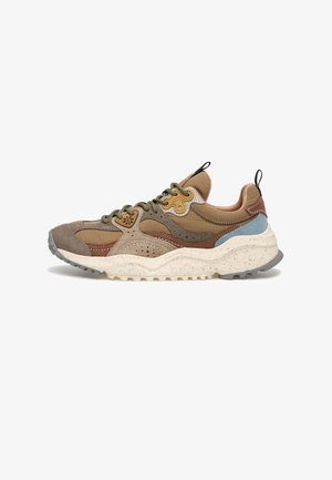 Sneaker outdoor chunky con pannelli marroni, blu e beige, lacci verde oliva e suola bianca maculata su sfondo bianco.