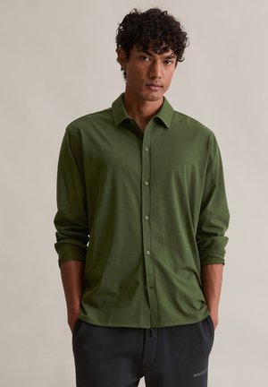 Grün longsleeve Hemd mit Button-Down-Kragen, aus weichem Stoff gefertigt, mit entspannter Passform und hochgekrempelten Ärmeln. Die Knöpfe passen in der Farbe zum Stoff.