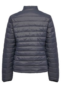 Marinblå pufferjacka med ett quiltat mönster. Har en ståkrage och elastiska avslutningar. Tyget verkar jämnt och lättviktigt.