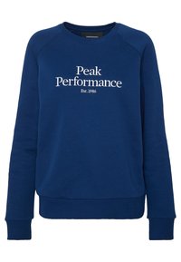 Námořnická modrá mikina s kulatým výstřihem, dlouhými rukávy a žebrovanými manžetami. Na přední straně je bílé vyšívané text: "Peak Performance Est.1986."