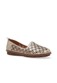 Lace-up shoe featuring a metallic gold perforated design, flat brown sole, and scalloped edges for added detail.