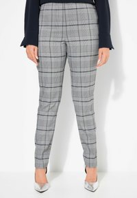 Grijze geruite broek heeft een getailleerde pasvorm, een gladde stof en een hoge tailleband. Versterkt met een subtiel ruitpatroon en een lichte textuur.