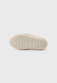 Beige rubber shoe sole with a circular and dotted texture pattern, flat design, and minimal tread detail.