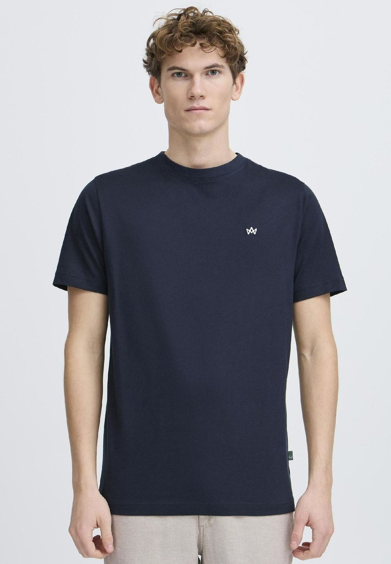 Marineblauwe katoenen t-shirt met een ronde hals, korte mouwen en een klein wit logo op de borst. Glad textuur, casual pasvorm.