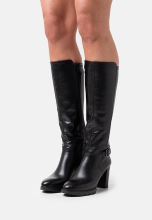 Bottes noires en cuir montantes avec une texture lisse, un large talon, une fermeture éclair sur le côté et un accent avec boucle près de la cheville.