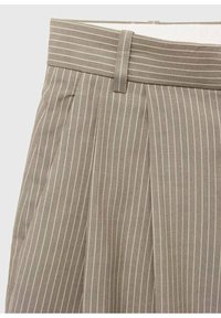 Pantalon beige avec fines rayures verticales blanches, devant plissé et passant de ceinture assorti à la taille.