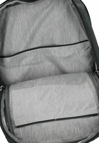 Grauer Rucksack innen mit glattem Stoff, zwei Reißverschlussfächern und einem größeren Fach zur Organisation. Strukturmuster im gesamten Inneren.