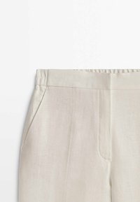 Linnenbyxor i off-white. Har en platt midja, sidofickor och en slät textur utan synliga mönster eller detaljer.