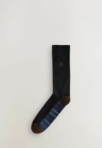Calzino nero con punta e tallone marroni a contrasto, caratterizzato da un motivo a righe multicolore lungo il lato, realizzato in un materiale liscio.