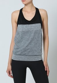 Grå och svart atletisk linne med horisontella ränder, ärmlös design, en mjuk textur och en åtsittande midja.