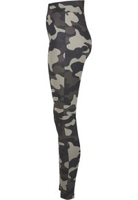 Leggings camouflage en tissu extensible, présentant des nuances de noir, gris et vert olive dans un motif abstrait. Texture lisse, taille haute.